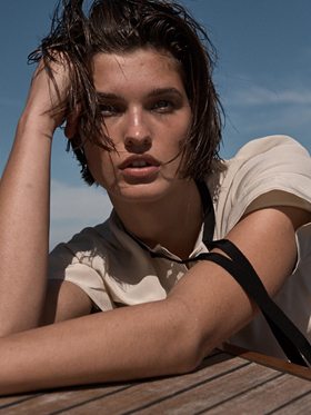 A close portrait, leaning on the teak, hair wet